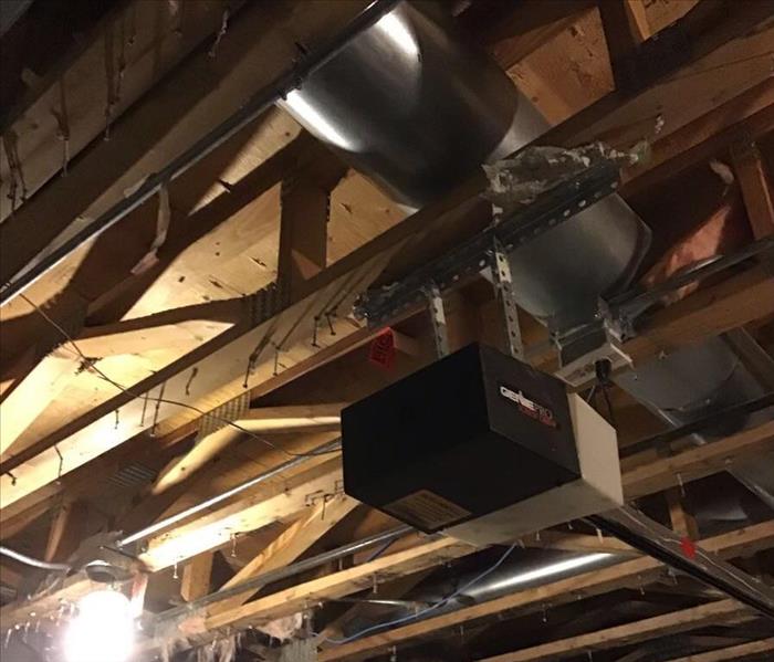 Open ceiling showing the studs above a garage door opener.