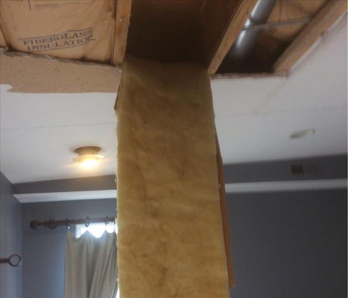Insulation hanging down from a ceiling. 