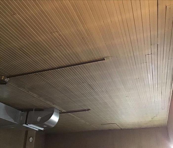 White ceiling covered in soot with furnace ducts on the ceiling.