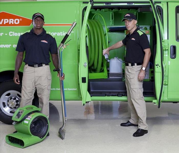 Green SERVPRO truck with 2 workers and a green air mover.