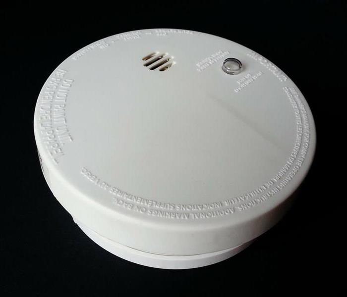 White round smoke alarm with a black background.