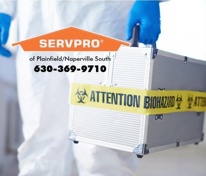 A person wearing protective gear is carrying a case labeled “biohazard.”